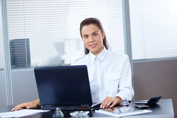 年轻漂亮的女商人坐在工作场所带着笔记本电脑 — 图库照片