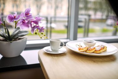Kahve fincanı ve süzme peynirli krep, kafe konseptinde kahvaltı.  