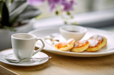 Kahve fincanı ve süzme peynirli krep, kafe konseptinde kahvaltı.  