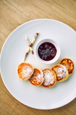 Beyaz tabakta çilek soslu süzme peynir krepleri, yakın görüş.