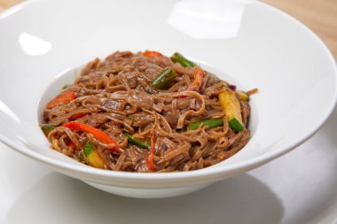 Beyaz tabakta sebzeli şehriye, yakın görüş.