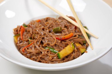 Sebzeli erişte ve beyaz tabakta çubuk, yakın görüş.