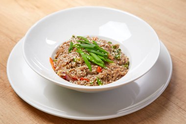 Beyaz tabakta sebzeli şehriye, yakın görüş.