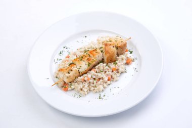 Beyaz tabakta arpalı tavuk kebabı, yakın görüş.