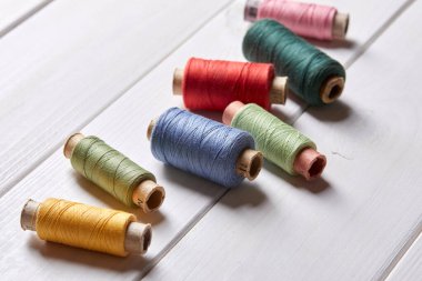 ahşap arka planda iplik ve iğneli bobinler, yakın görüş