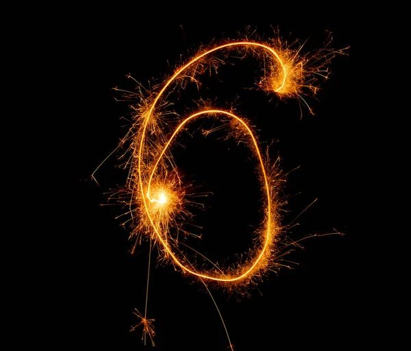 number six written with sparkler on black background