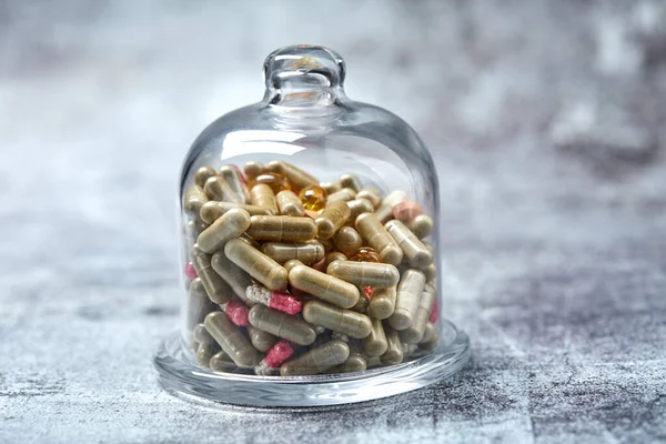 Pastillas Cápsulas Medicinales Bajo Cubierta Vidrio Sobre Superficie Gris —  Fotos de Stock