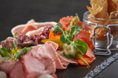 Et aperatifleri koyu taş tahtada, yakın görüş. 