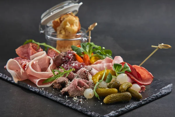 Et aperatifleri koyu taş tahtada, yakın görüş. 