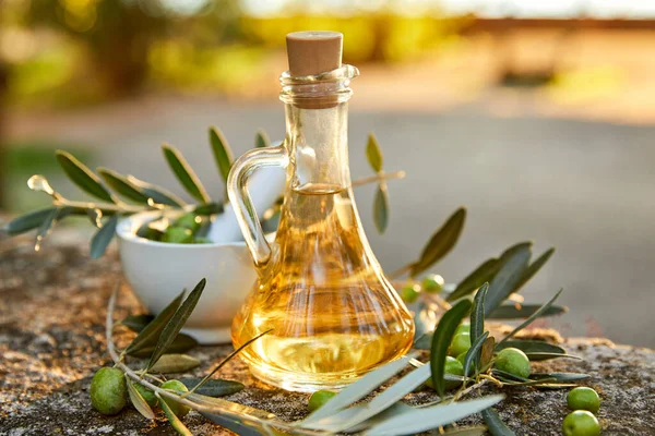 olive oil in bottle and branch of green olives, close view