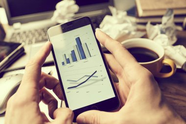 Erkek eller modern akıllı telefon kullanıyor. Ekranda grafik var. İş konsepti. 