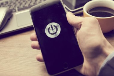 Erkek el ele tutuşan modern akıllı telefon ekranda güç düğmesi, iş konsepti 