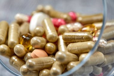 ilaç hapları ve kapsüller gri yüzeyde camda