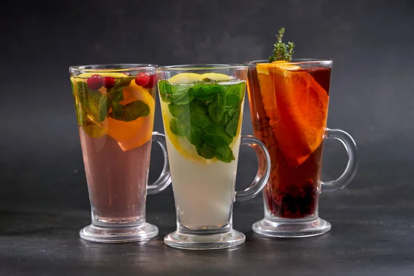 winter drinks with herbs and fruits in glasses, close view