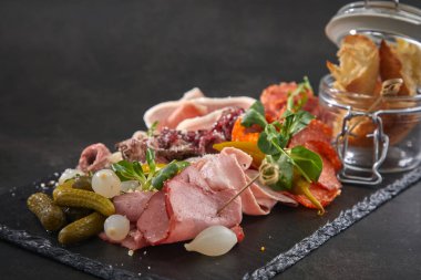 Et aperatifleri koyu taş tahtada, yakın görüş. 