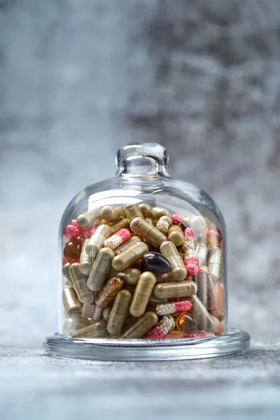 Pastillas Cápsulas Medicinales Bajo Cubierta Vidrio Sobre Superficie Gris — Foto de Stock