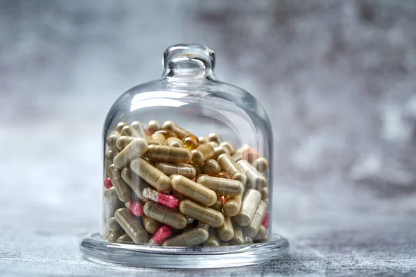 Pastillas Cápsulas Medicinales Bajo Cubierta Vidrio Sobre Superficie Gris — Foto de Stock