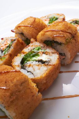 Beyaz arka planda izole edilmiş lezzetli suşi, yakın görünüm 