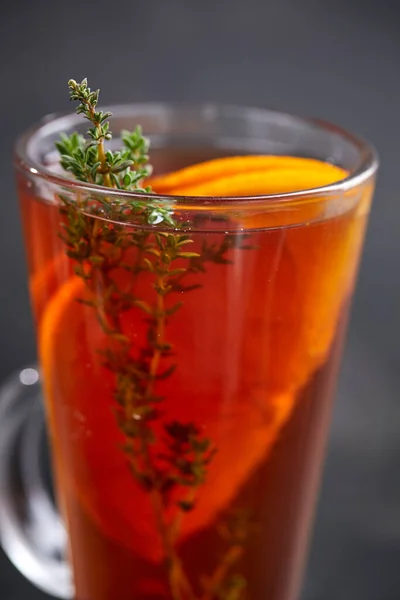 winter drink with herbs and fruits in glass, close view