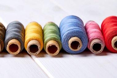 Ahşap arka planda iplikleri olan bobinler, yakın plan.  