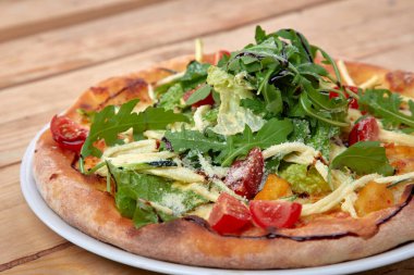 Tahta arka planda taze sebzeli pizza.