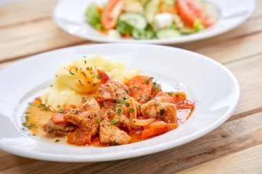 Beyaz tabakta patates püresi ve salata, yakın görüş. 