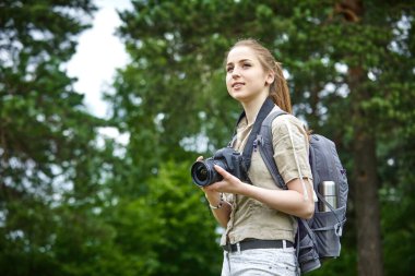 Yeşil çayırda kameralı genç bir kadın. 
