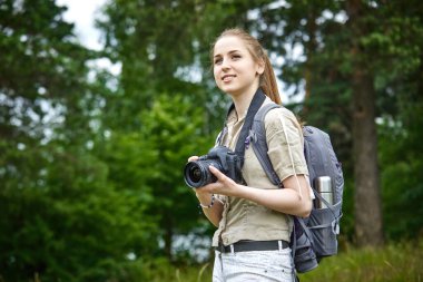 Yeşil çayırda kameralı genç bir kadın. 