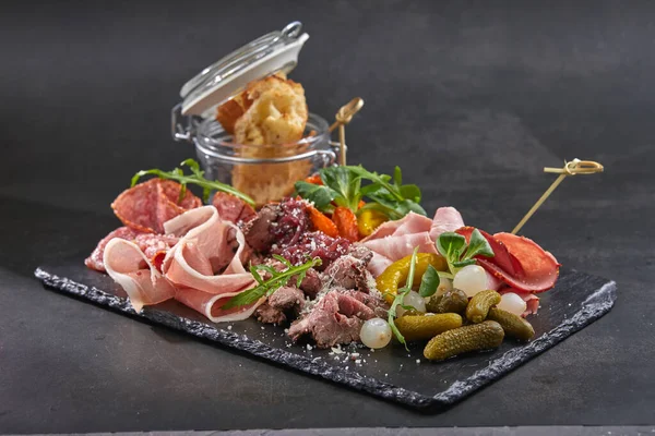 stock image meat appetizers on dark board, close view