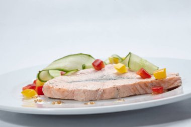 Beyaz tabakta sebzeli somon, yakın görüş. 