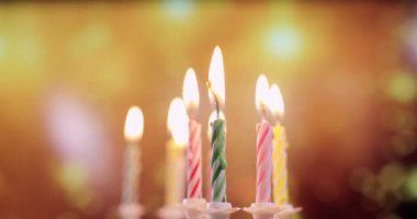 Renkli doğum günü mumlarının alevleri, yakın plan.