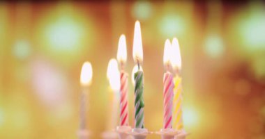 Renkli doğum günü mumlarının alevleri, yakın plan.