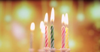 Renkli doğum günü mumlarının alevleri, yakın plan.