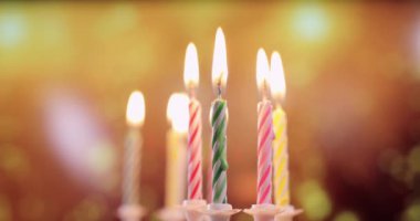 Renkli doğum günü mumlarının alevleri, yakın plan.