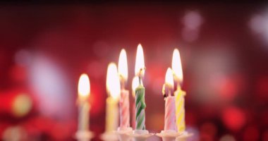 Renkli doğum günü mumlarının alevleri, yakın plan.