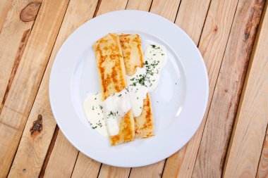 Beyaz tabakta ekşi kremalı krep, yakın görüş. 