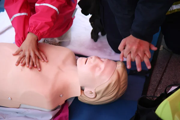 Practicing CPR chest compressioon on a dummy — Stockfoto