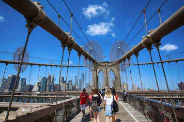 New York, ABD 23 Ağustos 2018 Brooklyn Köprüsü 'ndeki yaya geçidinde yaşayan insanlar, bu köprü Manhattan ve Brooklyn' i birbirine bağlıyor ve dünyanın en büyük asma köprüsünden biri..