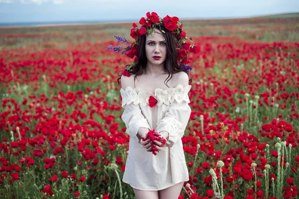 The girl poses on a poppy field — Stock Photo, Image