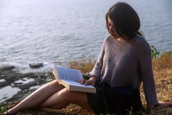 Una donna asiatica e un libro con vista mare — Foto Stock