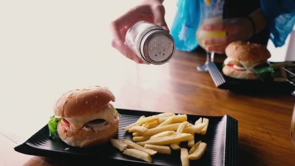 Hamburgertallrik Med Pommes Frites Och Kvinna Som Lägger Salt Pommes — Stockvideo