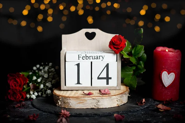 14 febbraio sul calendario dei cubi, fiore di rosa rossa e candele, arredamento — Foto Stock