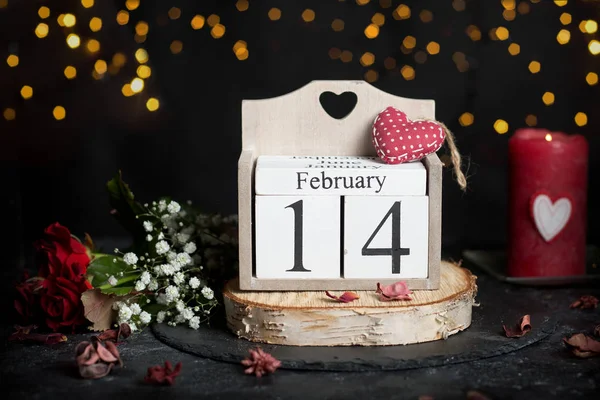14 febbraio sul calendario dei cubi, fiore di rosa rossa e candele, arredamento — Foto Stock