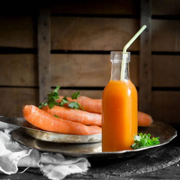 Karottensaft auf Holzgrund — Stockfoto