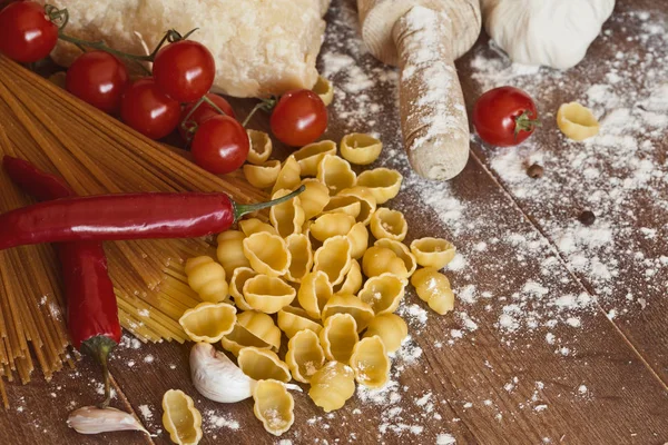 Овощи, масло, специи и макароны на столе — стоковое фото