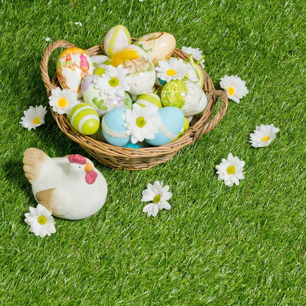 Ovos de páscoa decorados na cesta com margaridas — Fotografia de Stock