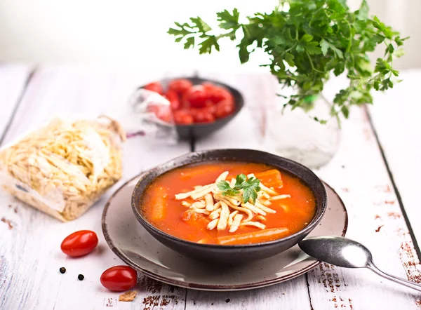 Sopa de tomate com macarrão em uma mesa de madeira — Fotografia de Stock