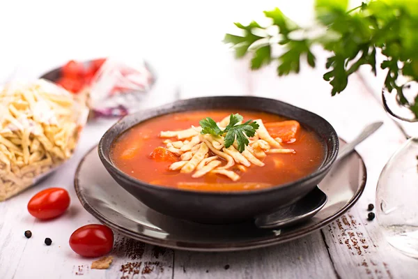 Sopa de tomate com macarrão em uma mesa de madeira — Fotografia de Stock