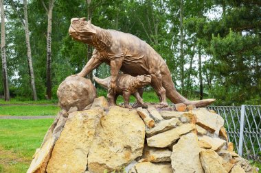 Bir dinozor bir bebekle heykeli
