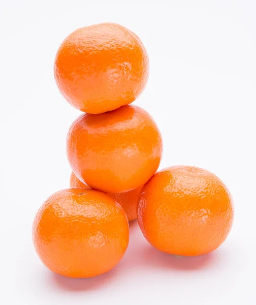 Pilha de frutos de tangerina frescos brilhantes em um fundo branco — Fotografia de Stock